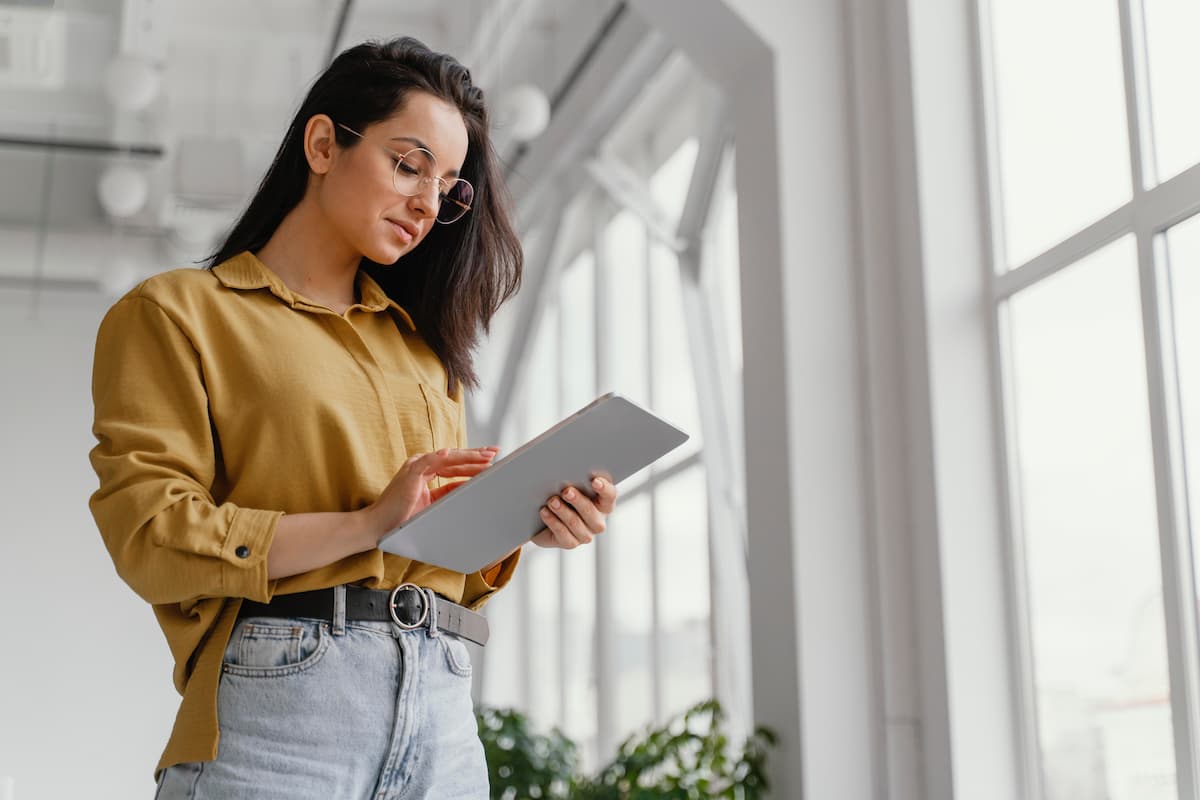 young-businesswoman-checking-her-tablet-with-copy-space-2 Agent immobilier tiens une tablette