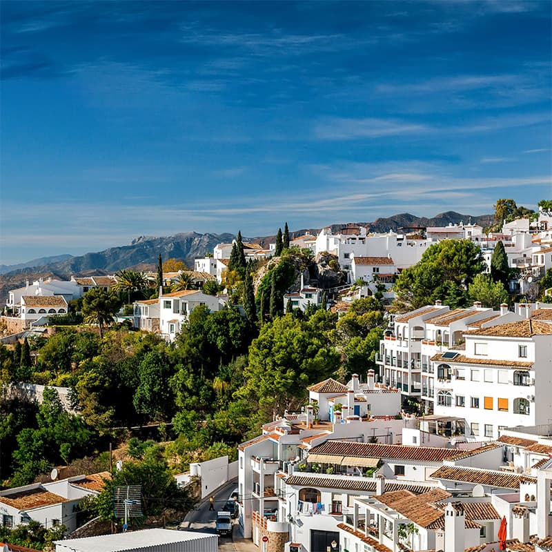 Vue de Mijas Vue pittoresque de Mijas avec ses maisons blanches traditionnelles entourées de verdure et montagnes en arrière-plan