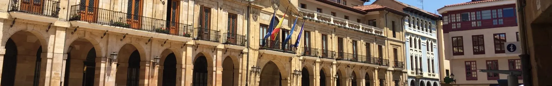 Place urbaine avec arcades et drapeaux espagnols sur les bâtiments