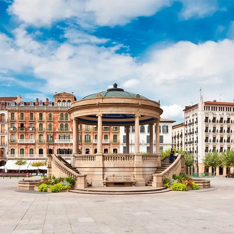 Pampelune1 Kiosque en pierre sur une place urbaine avec bâtiments historiques en arrière-plan
