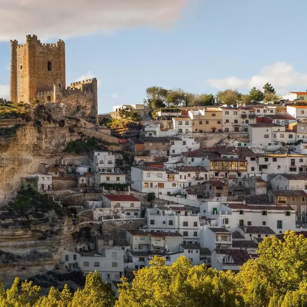 Maisons blanches à flanc de falaise à Alcalá del Júcar, village pittoresque d’Espagne avec château médiéval