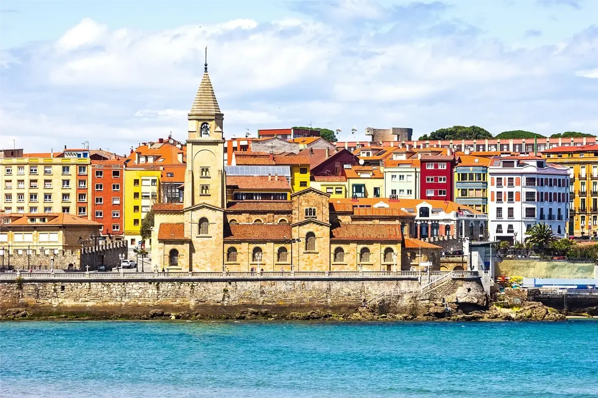 Gijon Vue de la côte avec église et maisons colorées au bord de la mer