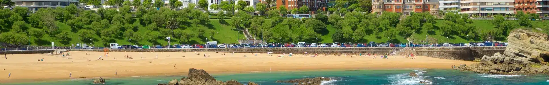 Santander Plage de sable avec baigneurs et rochers au premier plan