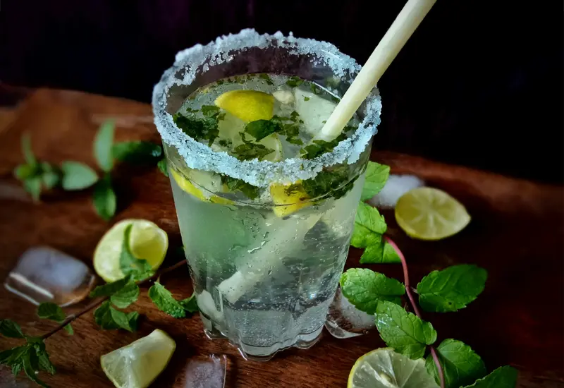 mojito-cocktail-traditionnel-espagne Verre de mojito avec citron vert, menthe et sucre givré, représentant un cocktail rafraîchissant en Espagne