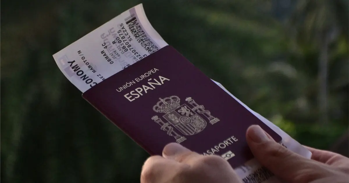 Gros plan sur un passeport espagnol avec billet d’avion, symbolisant visa, résidence et voyage en Espagne