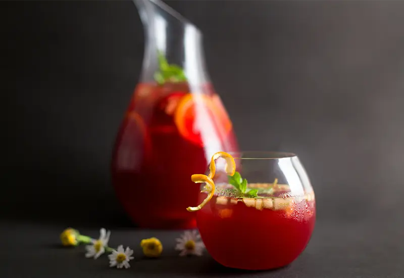 sangria-boisson-traditionnelle-espagnole Verre et carafe de sangria garnis de fruits, symbole de la boisson traditionnelle espagnole
