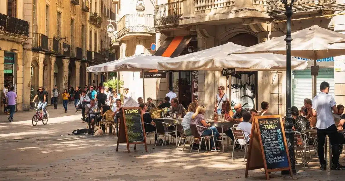 Terrasse animée d’un bar à tapas en Espagne avec menu affiché, illustrant le coût de la vie et la restauration