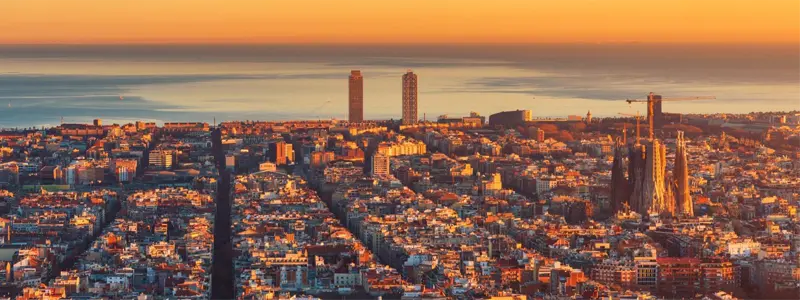barcelone-investissement-immobilier-espagne-2026 Vue aérienne de Barcelone et de la Sagrada Familia au lever du soleil, destination phare pour les investisseurs internationaux en 2026