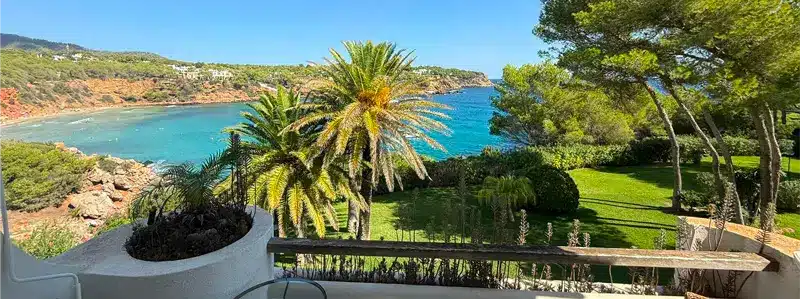 ibiza-investissement-immobilier-haut-de-gamme-espagne-2026 Vue depuis une terrasse sur la mer turquoise d’Ibiza, destination prisée pour les investisseurs haut de gamme en Espagne en 2026